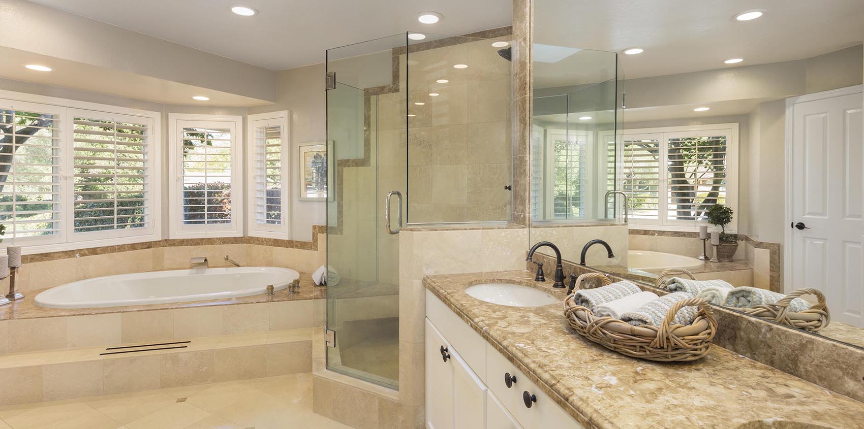 Luxury bathroom interior in marble with glass shower and round d